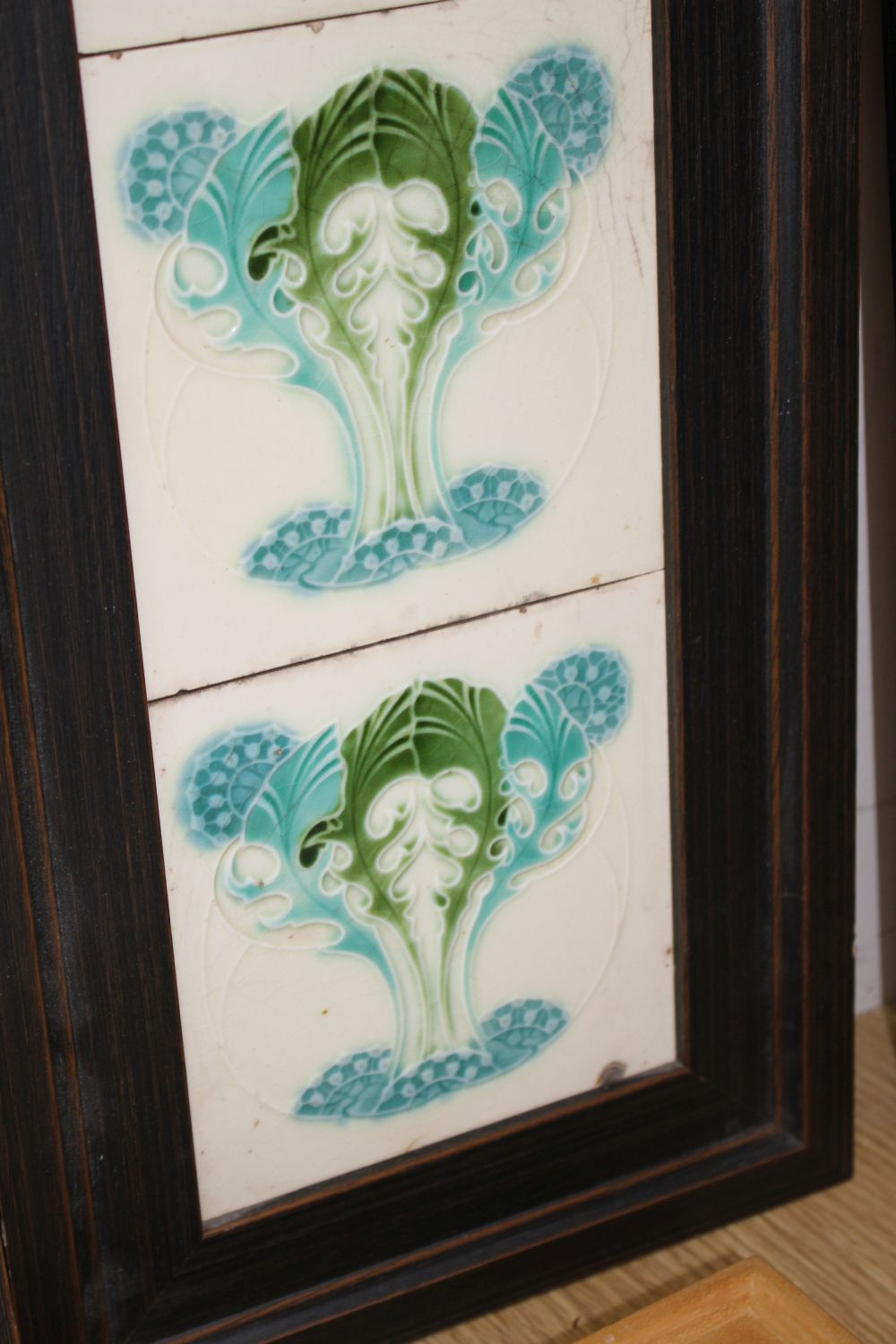 A pair of Victorian apple blossom tile panels and a set of six Art Nouveau foliate design tiles, all framed